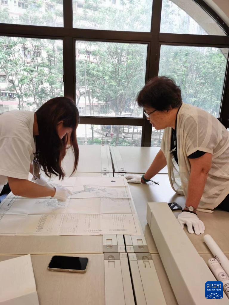 6月12日，東江縱隊(duì)老戰(zhàn)士劉克強(qiáng)的外孫女黎詩(shī)雅（左）與東江縱隊(duì)老戰(zhàn)士后人、香港抗戰(zhàn)史研究者王玉珍在香港歷史檔案大樓查閱史料。新華社發(fā)