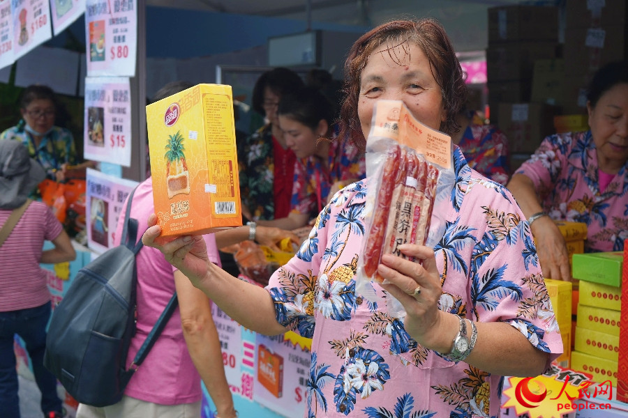 商戶熱情展示特色食品。人民網(wǎng) 實(shí)習(xí)生王悅 攝