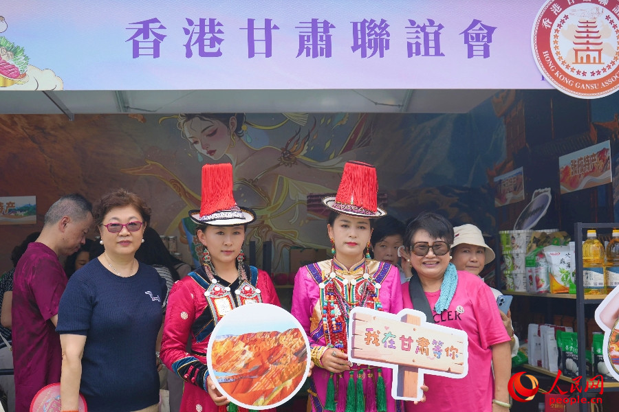 市民與身著民族服飾的工作人員合影。人民網(wǎng) 實習(xí)生王悅 攝