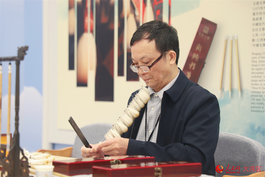 文港毛筆制作技藝國家級非遺代表性傳承人周鵬程正在示范。人民網 吳宇揚揚攝