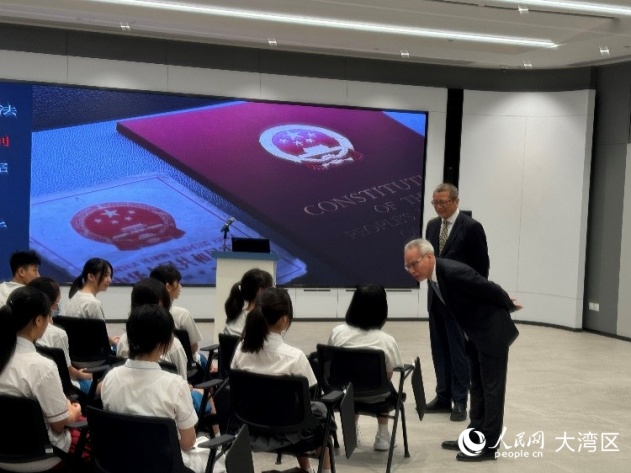 岑浩輝（右一）與正在傾聽普法講座的中學(xué)生們交流。人民網(wǎng)記者 富子梅攝