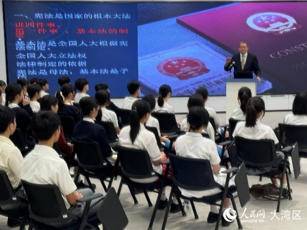 澳門大學(xué)法學(xué)院教授駱偉建在青少年普法講座上為中學(xué)生講解憲法和澳門基本法。人民網(wǎng)記者 富子梅攝