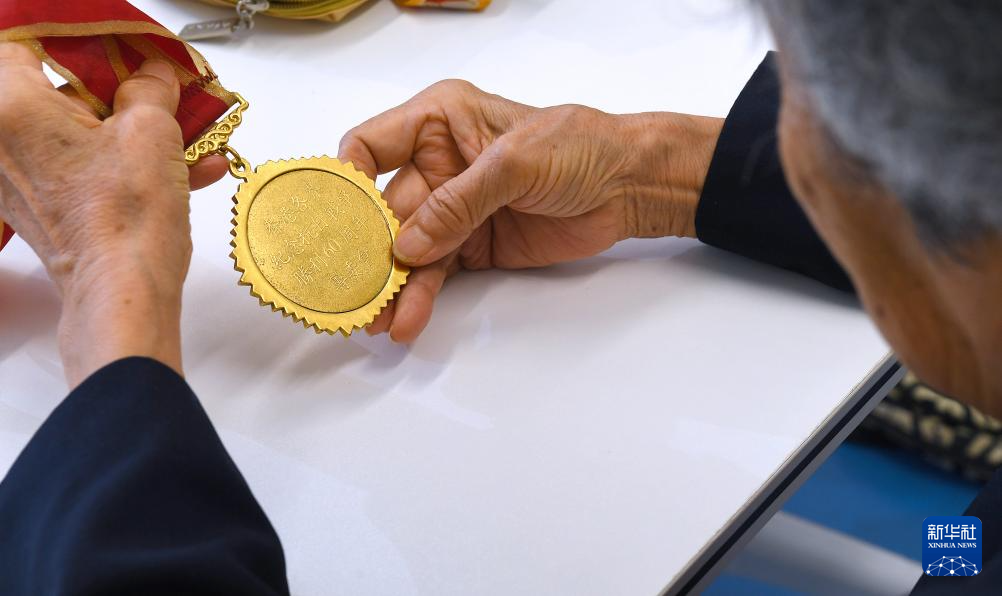 6月24日，在香港屯門欣田邨服務(wù)處，90歲的抗日老戰(zhàn)士林珍展示她榮獲的勛章。新華社記者 陳鐸 攝