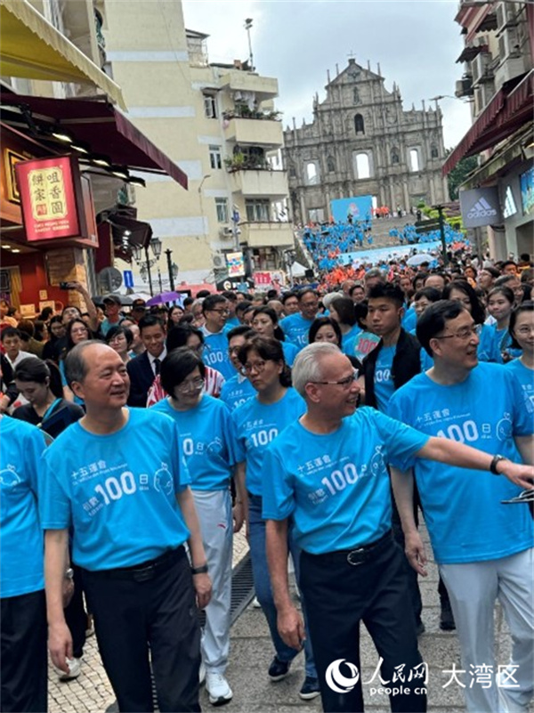 圖為岑浩輝身穿藍色運動背心，精神抖擻與眾人一同從大三巴牌坊起步，參與“迎百日 健步行”活動。人民網(wǎng)記者 富子梅攝