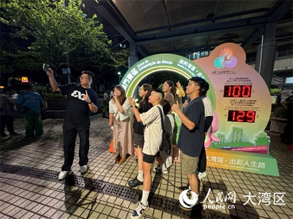 圖為澳門居民與全運會倒計時牌合影留念。人民網(wǎng)記者 富子梅攝