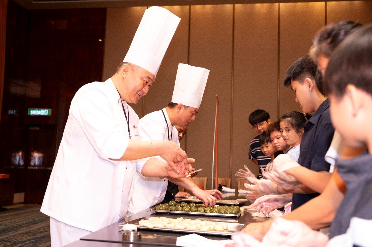 上海大廚現(xiàn)場手把手教小朋友們學(xué)習(xí)制作非遺點(diǎn)心。主辦方供圖