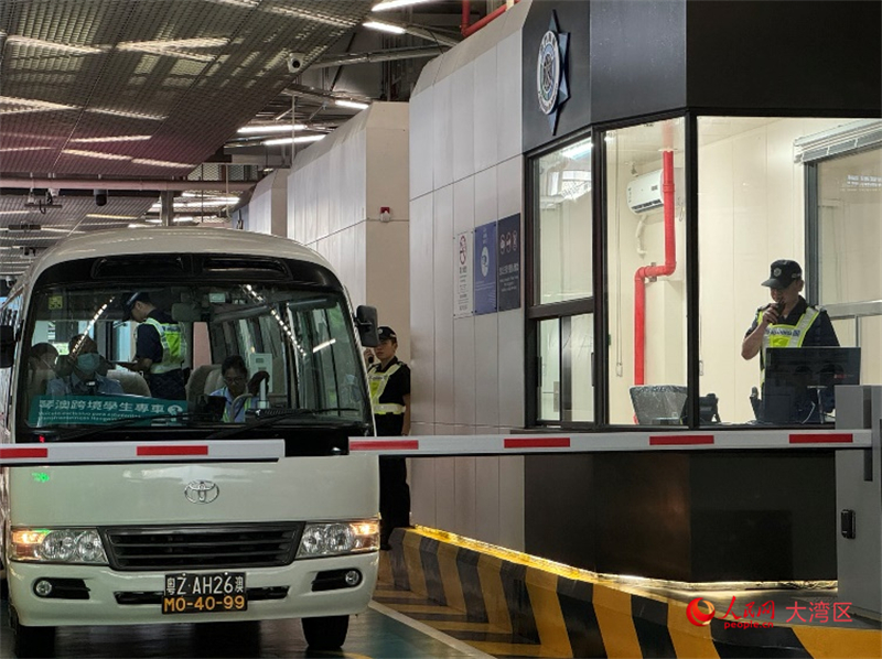 圖為第一輛跨境學(xué)生專(zhuān)車(chē)接受澳門(mén)海關(guān)登車(chē)查驗(yàn)、學(xué)生免下車(chē)通關(guān)服務(wù)新舉措。人民網(wǎng)記者 富子梅攝