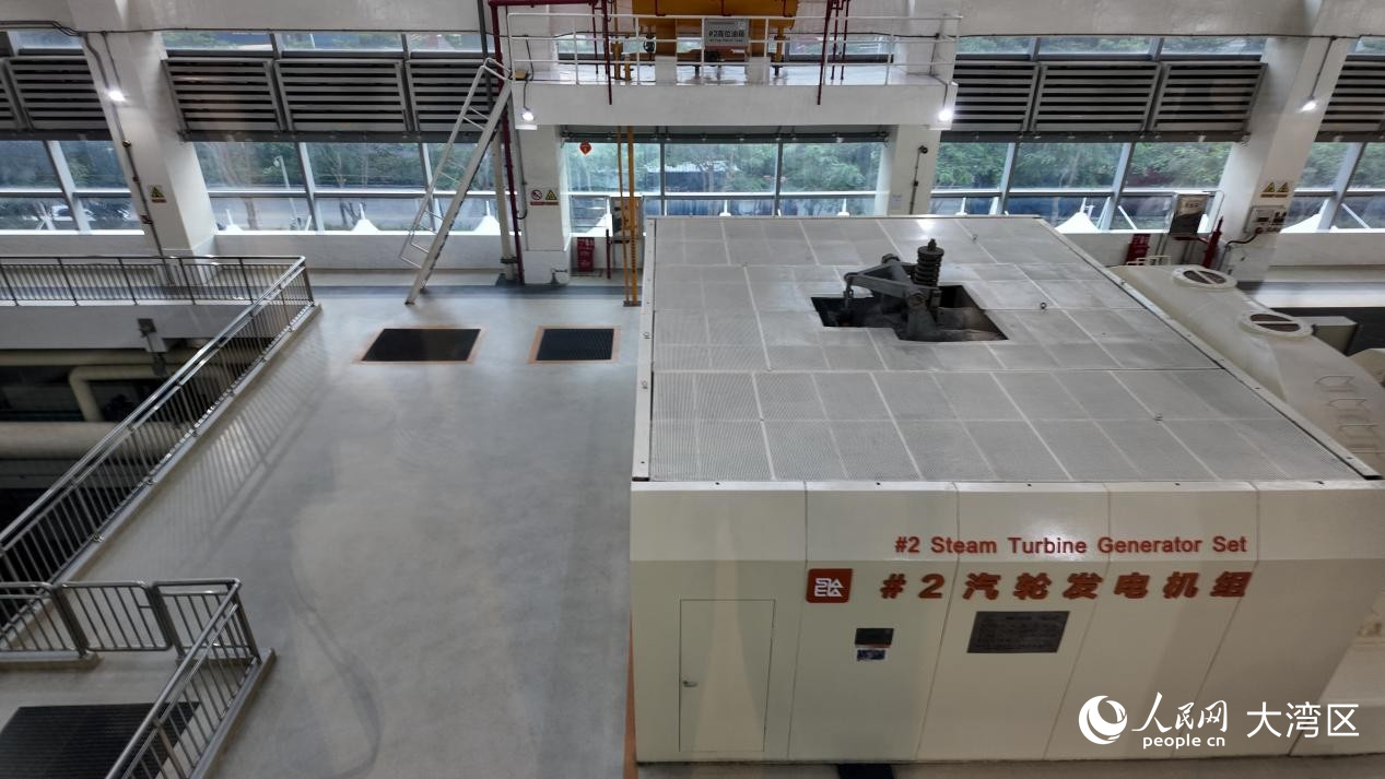 透過展廳玻璃可看到的巨大發(fā)電機(jī)組。 人民網(wǎng) 周錦佳攝