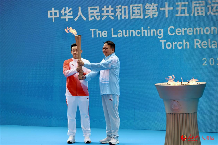 香港站首棒火炬手黃鎮(zhèn)廷從香港特區(qū)署理行政長官陳國基手中接過圣火。人民網(wǎng) 嚴小晶攝