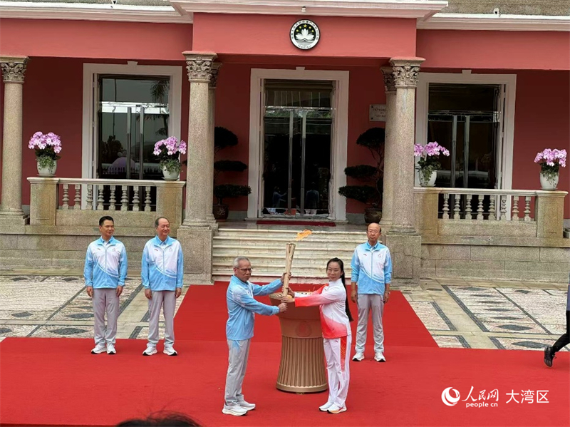 圖為澳門特區(qū)行政長官岑浩輝在火種盆點燃火炬，授予第一棒火炬手澳門武術(shù)名將、2023杭州亞運武術(shù)金牌運動員李祎。人民網(wǎng)記者 富子梅攝