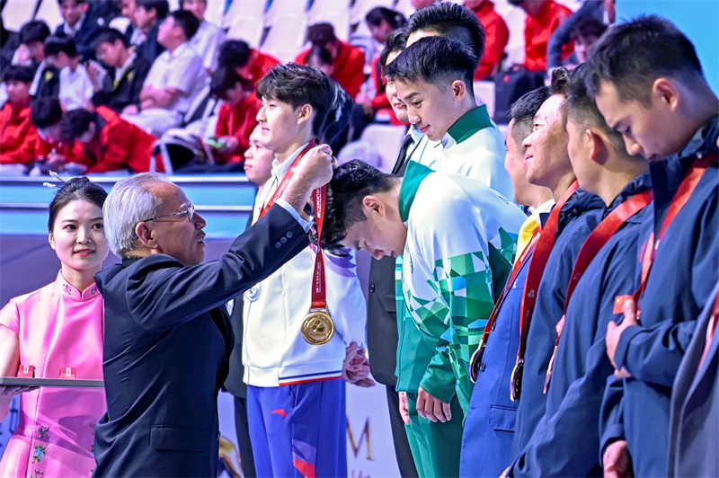 圖為岑浩輝為全運會空手道業(yè)余團體冠亞季軍頒獎。澳門特區(qū)政府新聞局供圖