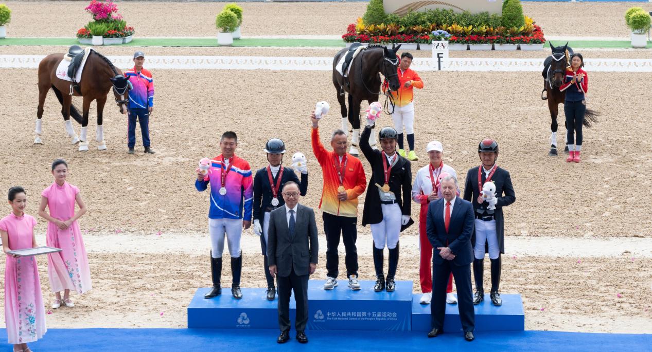 圖.香港賽馬會(huì)主席廖長(zhǎng)江、行政總裁應(yīng)家柏向十五運(yùn)會(huì)馬術(shù)項(xiàng)目盛裝舞步個(gè)人賽的獲獎(jiǎng)運(yùn)動(dòng)員頒發(fā)獎(jiǎng)牌和紀(jì)念品。香港賽馬會(huì)供圖