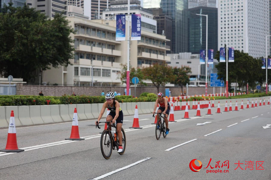 鐵人三項女子個人賽自行車路線以中環(huán)商業(yè)區(qū)為背景，途經(jīng)政府總部、立法會綜合大樓、香港摩天輪等。人民網(wǎng)記者 馮學(xué)知攝
