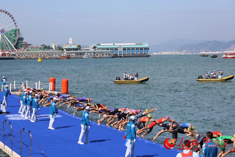 鐵人三項男子個人賽參賽選手跳入維多利亞港，開始游泳項目的競逐。人民網(wǎng)記者 馮學(xué)知攝