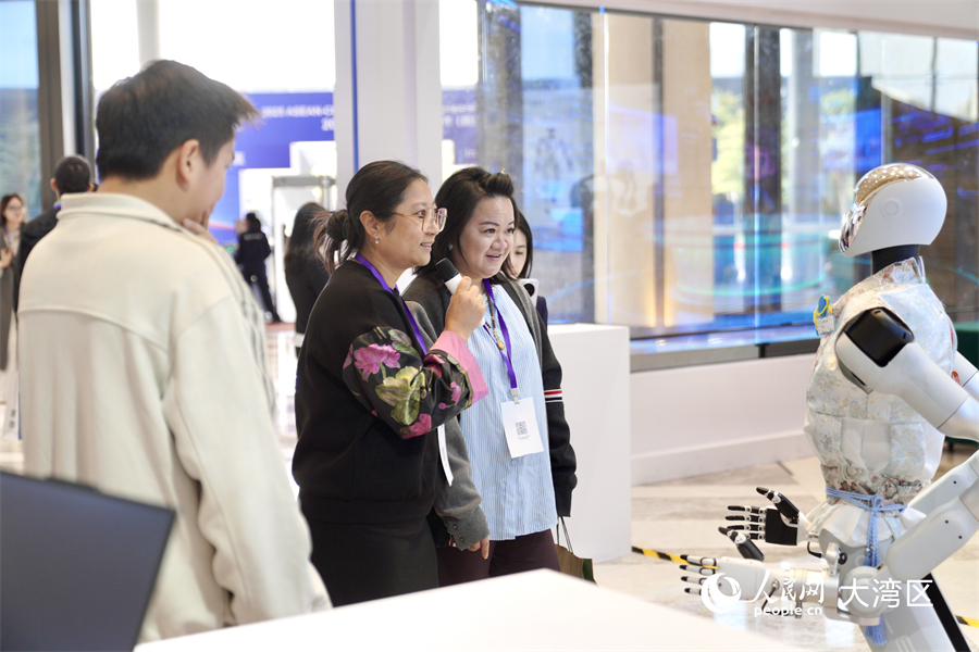 參會(huì)嘉賓在2025大灣區(qū)—東盟經(jīng)濟(jì)合作（前海）論壇現(xiàn)場(chǎng)的產(chǎn)品展區(qū)內(nèi)聽(tīng)取講解并參與互動(dòng)。人民網(wǎng)記者 許崢攝