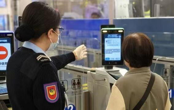 圖為工作人員指導(dǎo)通關(guān)人士登記使用“刷臉”模式。澳門特區(qū)治安警察局供圖