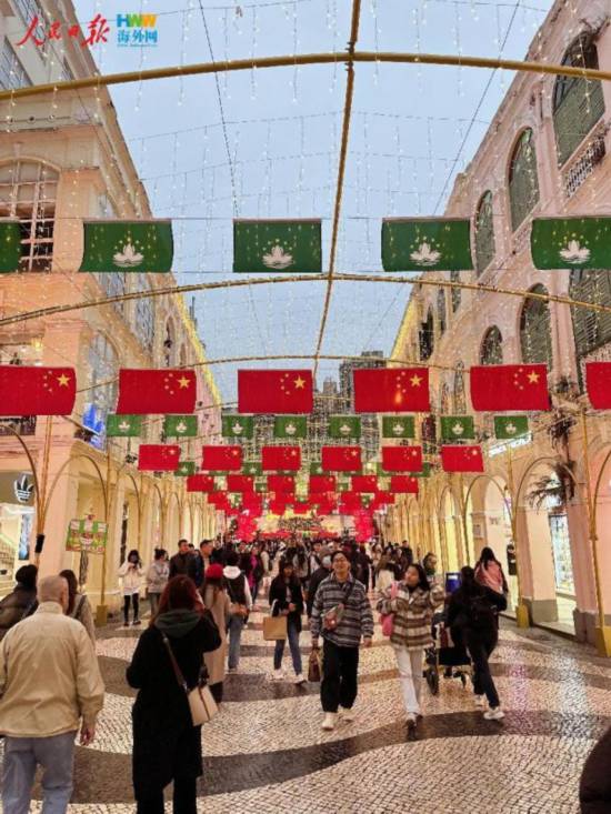 12月15日，在澳門街頭，鮮艷的五星紅旗和澳門特區(qū)區(qū)旗迎風(fēng)飄揚。（海外網(wǎng) 牛寧 攝）
