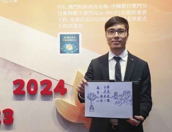 12月18日，澳門(mén)中銀員工梁銘坤在展示祝福語(yǔ)。