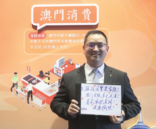 12月18日，澳門(mén)中銀員工王金思在展示祝福語(yǔ)。