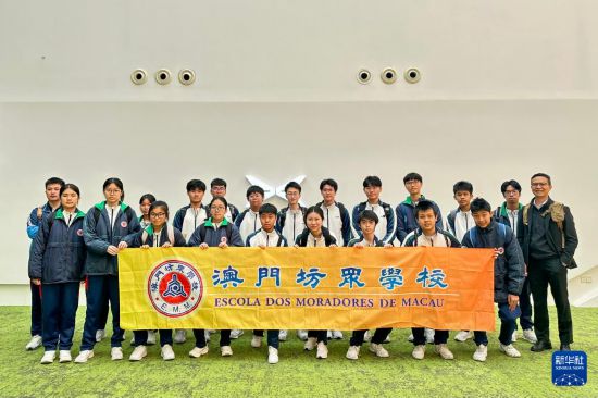澳門坊眾學(xué)校學(xué)生在小鵬汽車廣州總部合影留念（3月21日攝）。新華社記者 郭雨祺 攝