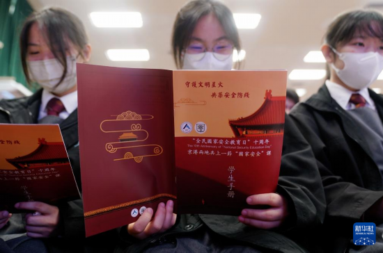   4月9日，在香港培僑中學(xué)，學(xué)生在“京港兩地共上一堂國安課”活動上閱讀學(xué)生手冊。新華社發(fā)（王申攝）