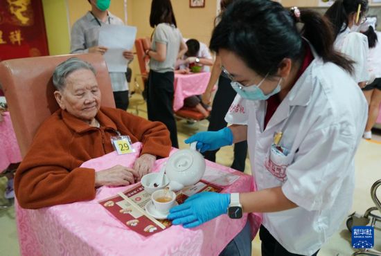 5月24日，在香港松悅園耆和護養(yǎng)院，身穿白衫的伙計在“茶樓”售賣茶點，端茶倒水。新華社發(fā)（王申 攝）