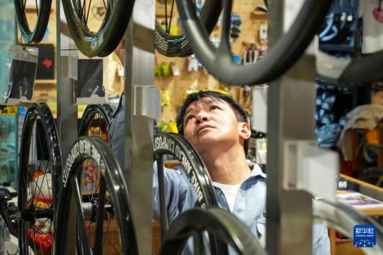 10月13日，在香港荃灣環(huán)貿(mào)廣場(chǎng)，黃金寶在他經(jīng)營(yíng)的單車店內(nèi)整理商品。新華社記者 朱煒 攝