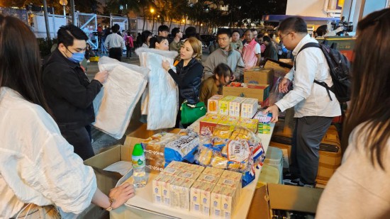 11月26日，受火災影響的居民在跨部門援助站領(lǐng)取救援物資。新華社記者 陳鐸 攝