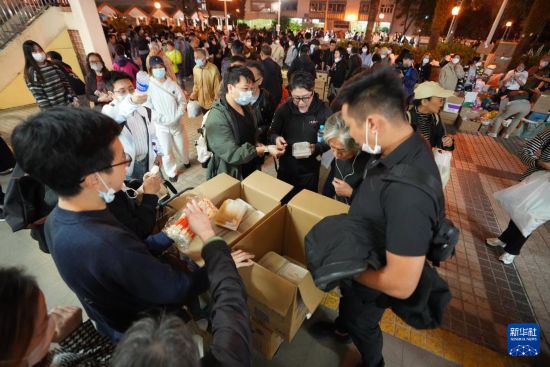 11月27日，義工在宏福苑附近向受火災(zāi)影響的市民派發(fā)物資。新華社發(fā)（呂小煒攝）