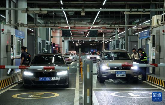 12月23日零時，“粵車南下”入境香港市區(qū)的首批通關(guān)車主在“一站式”通道辦理通關(guān)手續(xù)。新華社記者 黃國保 攝