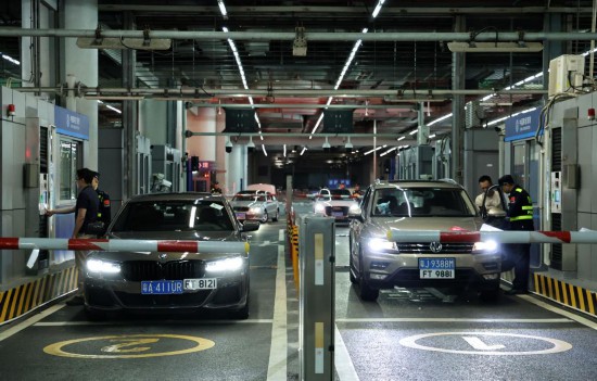 12月23日零時，“粵車南下”入境香港市區(qū)的首批通關車主在“一站式”通道辦理通關手續(xù)。新華社記者 黃國保 攝