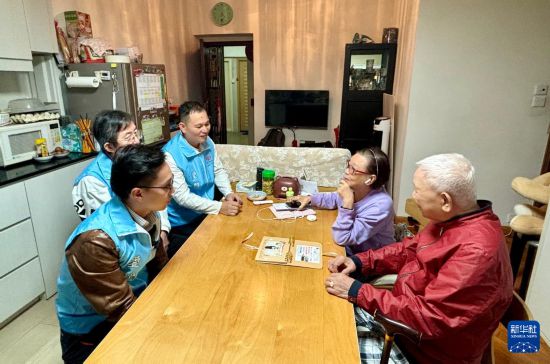 　　11月18日，穆家駿（前左）與關(guān)愛隊成員在灣仔利昌大廈走訪社區(qū)長者。新華社記者 陳鐸 攝