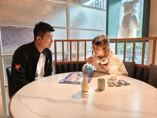 　　11月24日，劉承銘（左）在餐廳與食客交談。劉承銘在香港尖東經(jīng)營(yíng)一家咖啡簡(jiǎn)餐廳，從2024年夏天開(kāi)始承辦游戲與動(dòng)漫IP主題餐廳活動(dòng)。新華社記者 劉英倫 攝