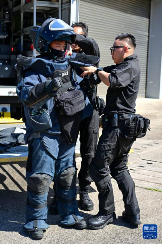 香港警務(wù)處爆炸品處理課隊員協(xié)助同事穿防爆服（2025年11月6日攝）。新華社記者 朱煒 攝