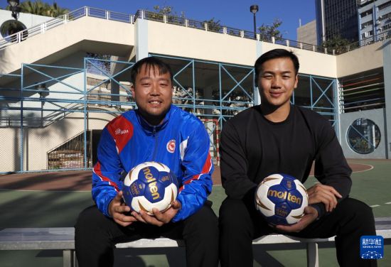 在香港新蒲崗彩虹道150號的露天游樂場，香港男子手球隊主教練許文邦（左）和隊長謝永輝一起接受記者拍照（2025年12月17日攝）。新華社發(fā)（王申攝）