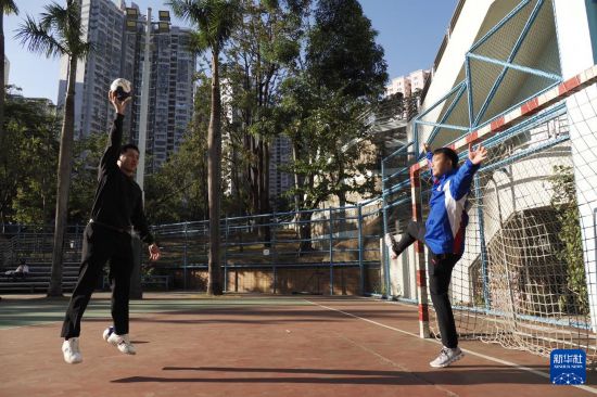　在香港新蒲崗彩虹道150號的露天游樂場，香港男子手球隊主教練許文邦和隊長謝永輝（左）在打手球（2025年12月17日攝）。新華社發(fā)（王申攝）