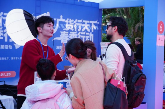 在“廣貨行天下”春季行動(dòng)消費(fèi)電子專場(chǎng)促銷活動(dòng)現(xiàn)場(chǎng)，國(guó)外游客與商家交談。新華社記者 王豐 攝
