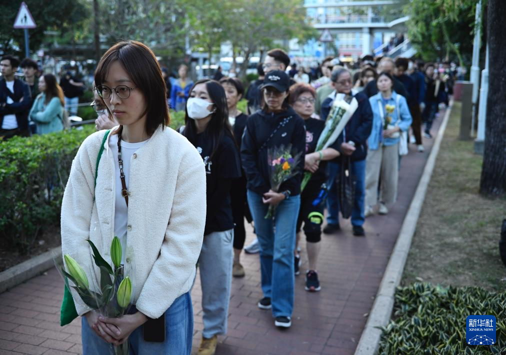 11月29日，在香港大埔宏福苑附近公園，人們排起長隊(duì)等待獻(xiàn)花。新華社發(fā)（王申攝）
